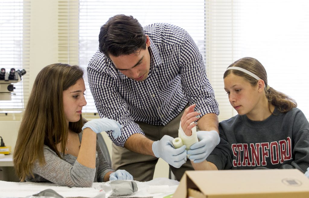 Reilly Filter 14, from Palo Alto High School and Maddie Feldmeier 15, from Palo Alto High School learn to make cast from Dr Jason Dragoo M.D. (center) during a Sports lab: Medicine on the sidelines at Med School 101 at Stanford University School of Medicine on Friday, March 28, 2014. ( Norbert von der Groeben/ Stanford School of Medicine )