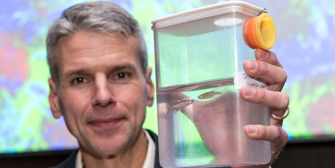 scientist Will Talbot holding container with fish
