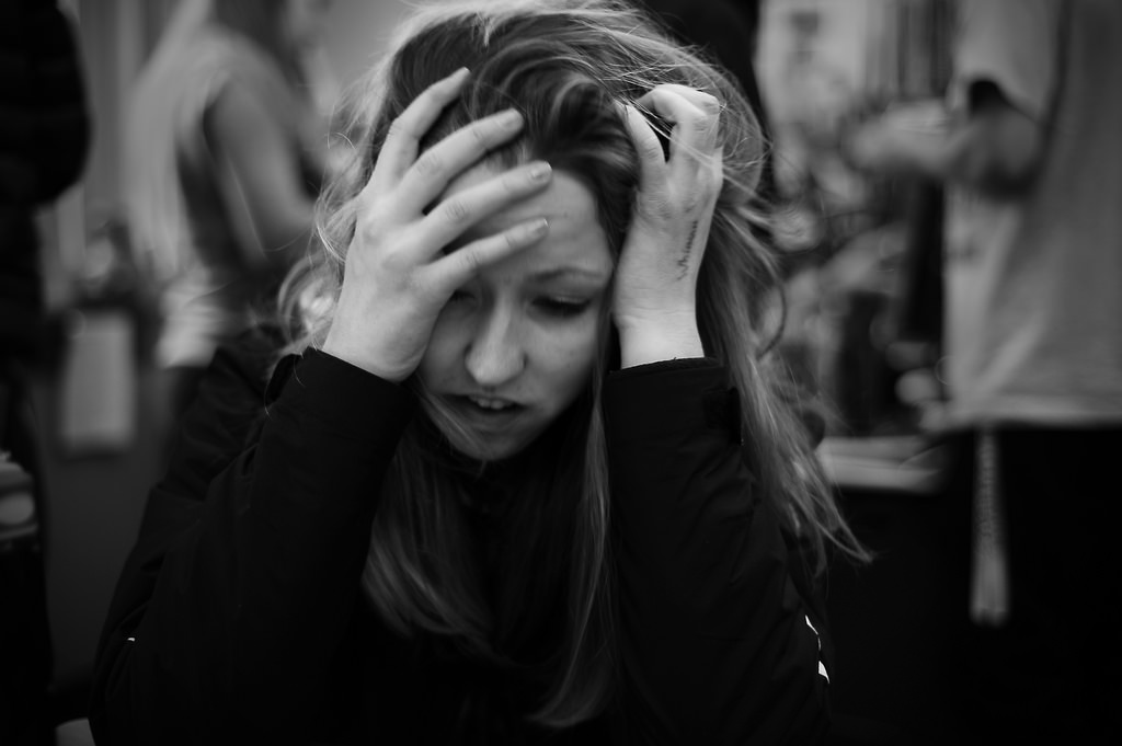 Stressed woman holding her head in her hands