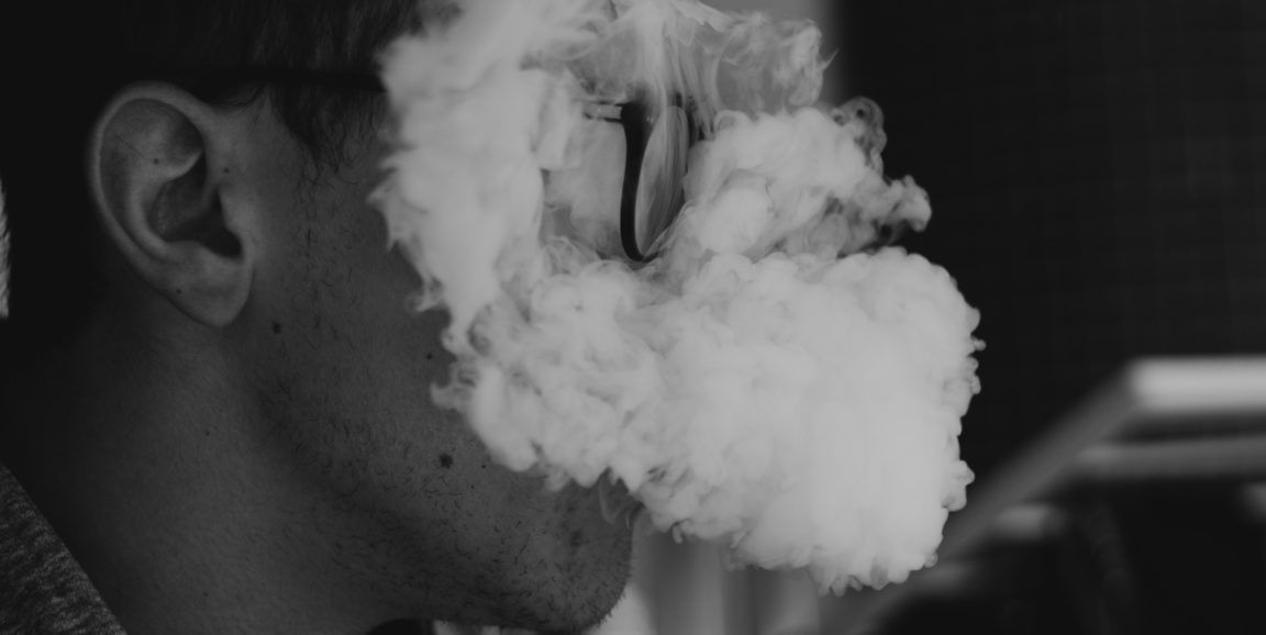 person's face covered by cloud of vaping smoke
