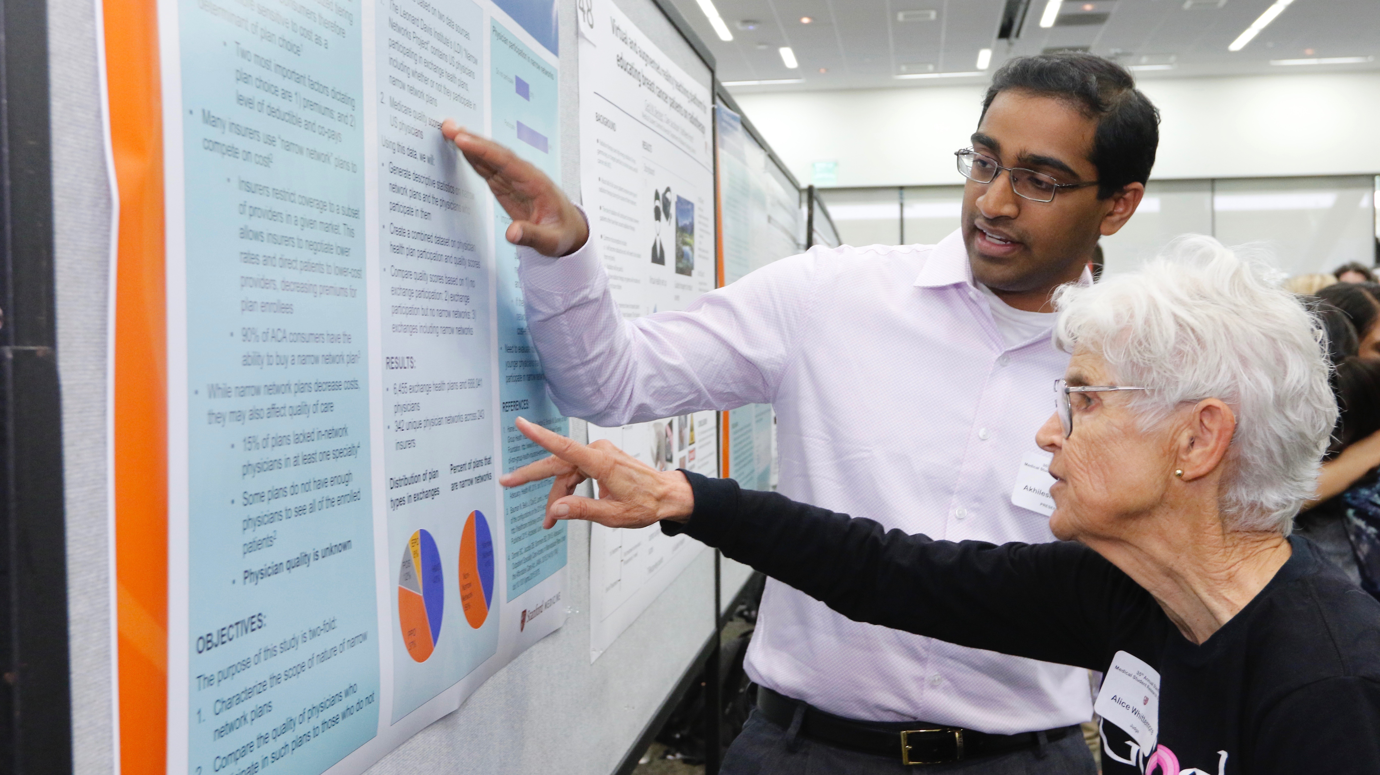 student showing professor a poster
