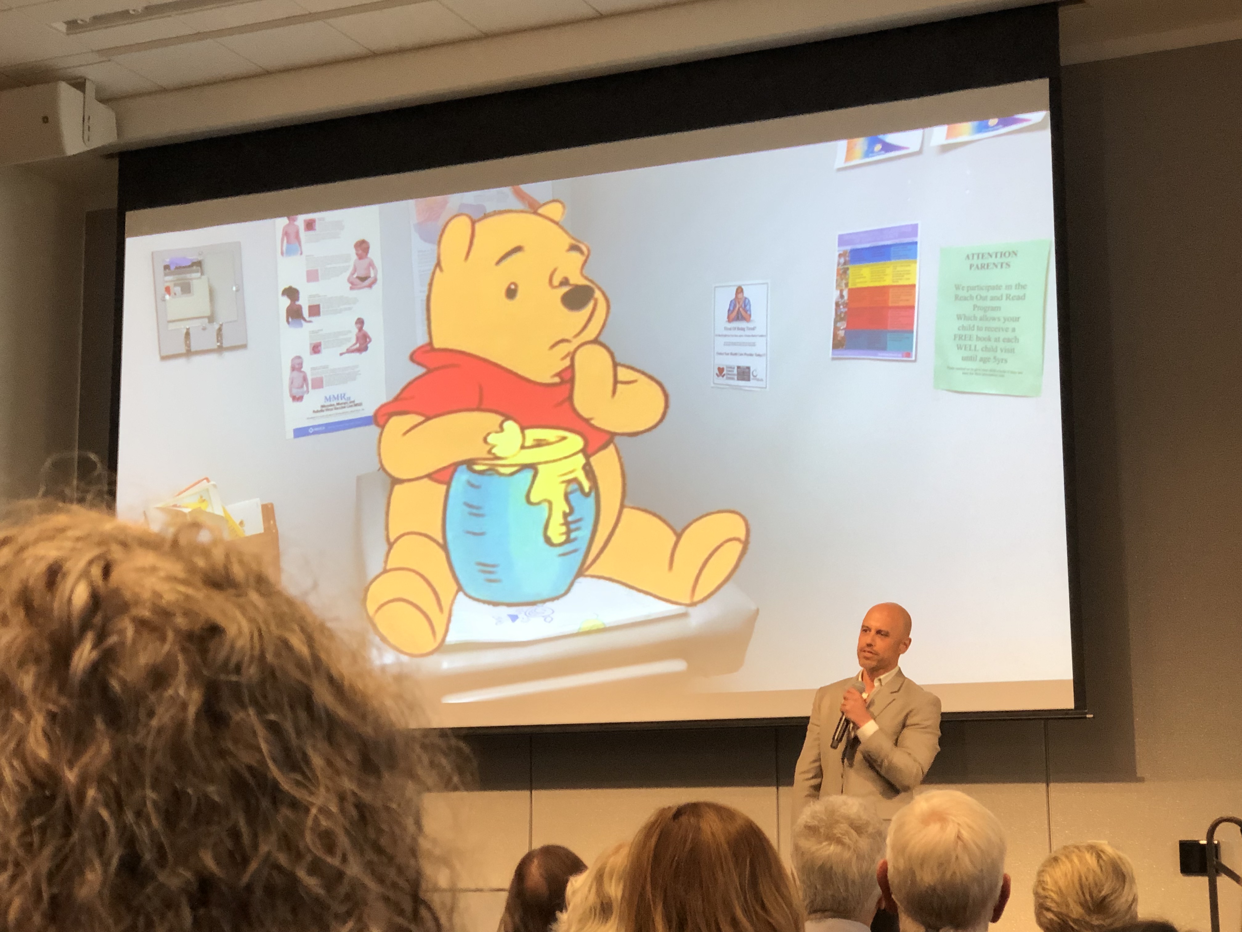 Zubin Damania, aka ZDoggMD, stands in front of an image of Winnie the Pooh