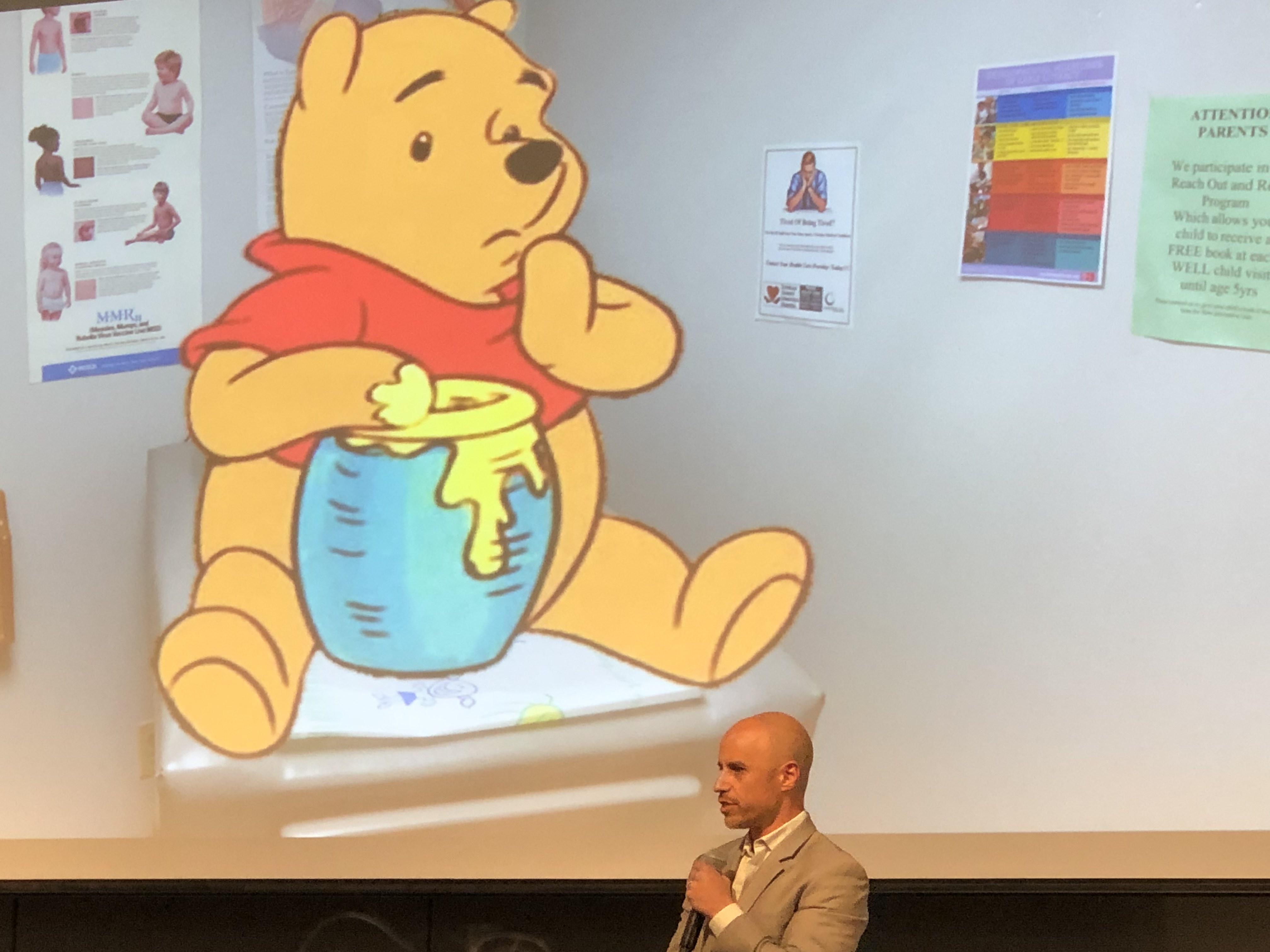 Doctor Zubin Damania presents patient Winnie the Pooh at the 2019 Jonathan J. King Lecture Series