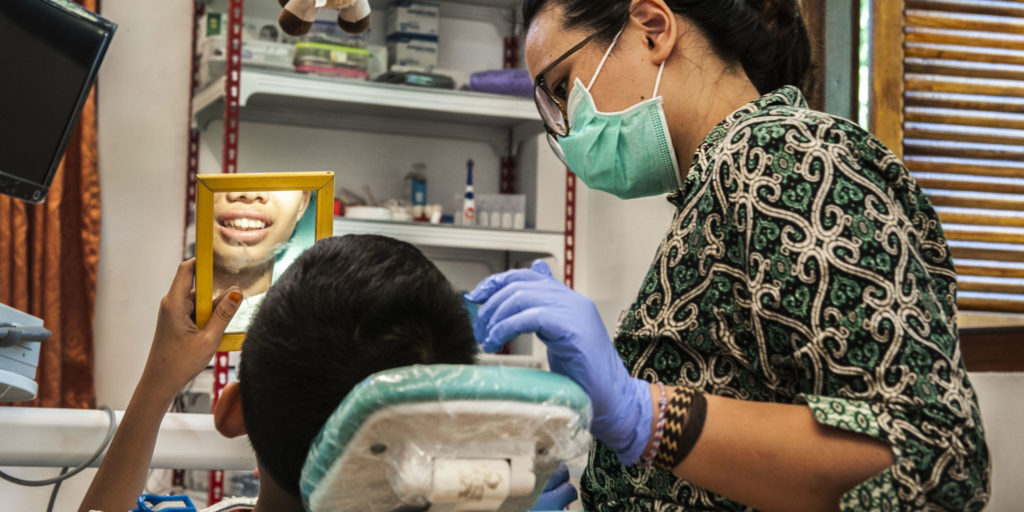 A health professional provides dental care at a clinic in Indonesia