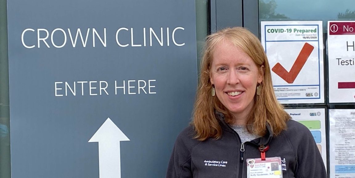 Kelly Sanderson in front of CROWN clinic sign